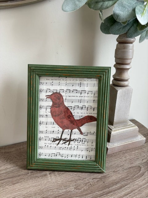 Green wood frame with bird painted on music sheet