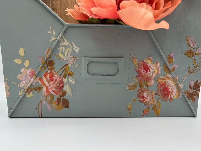 Floral-patterned box with a handle on a white background