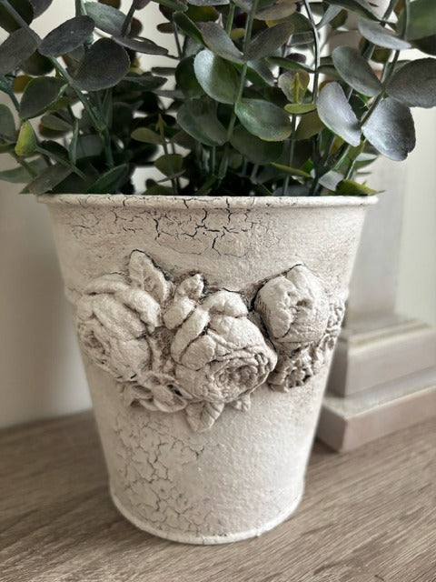 Metal pot with clay floral design and faux greenery