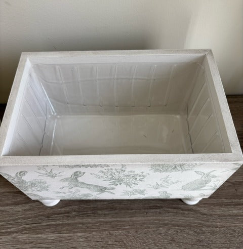 Decorative box with rabbit design and gold keyhole.