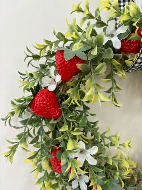 Decorative wreath with strawberries and a checkered ribbon