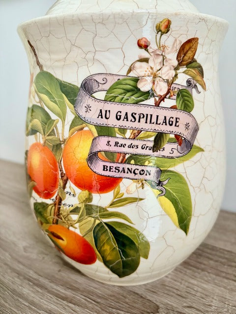 Decorative caniste with botanical design and text on a light background