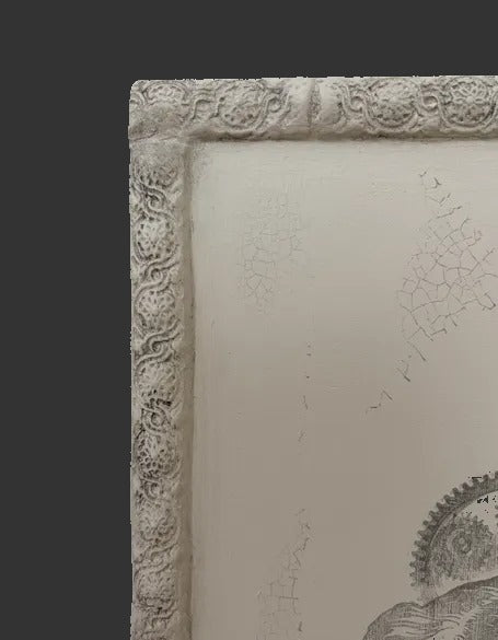 Decorative clay frame with intricate carvings on a dark background
