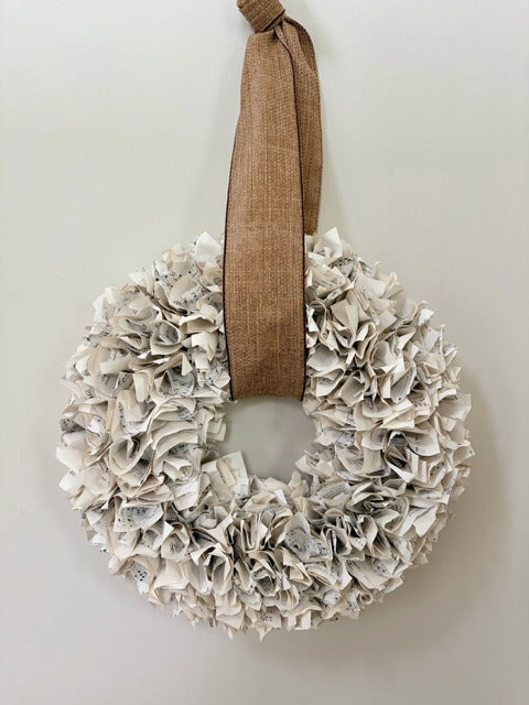 Wreath made of paper with a brown ribbon on a white background