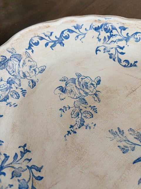 Close-up of a decorative plate with blue floral patterns on a wooden surface