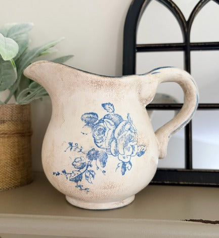 Ceramic pitcher with blue floral design on a shelf