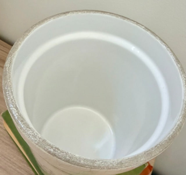 White ceramic canister with a textured rim 