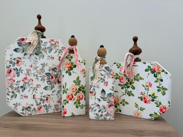 Set of decorative pumpkins with floral patterns on a wooden surface.