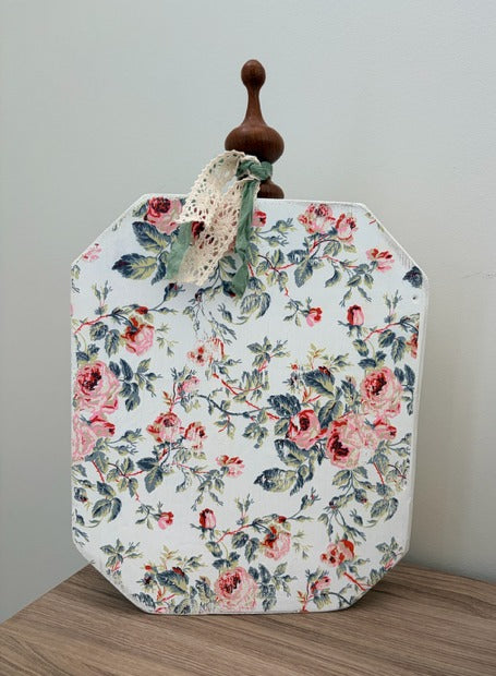 Floral-patterned pumpkin with wooden handle on a wooden surface