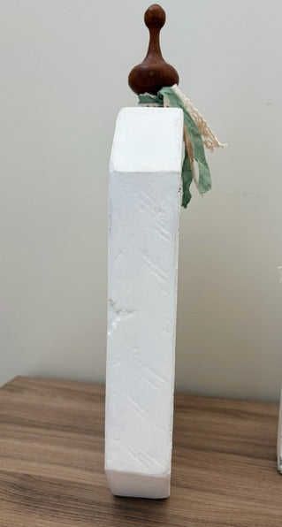 White rectangular pumpkin with a wooden top on a wooden surface