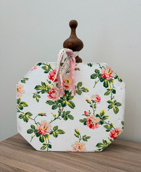 Floral-patterned pumpkin with a wooden knob on a wooden surface