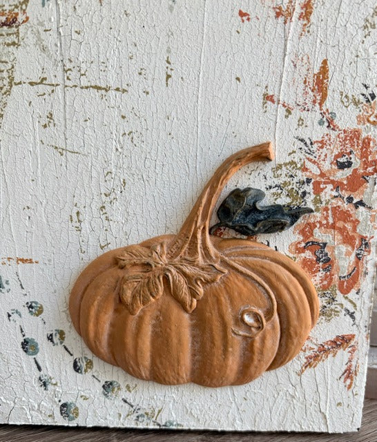 Decorative pumpkin on a textured surface with floral patterns