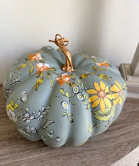 Decorative pumpkin with floral patterns on a wooden surface
