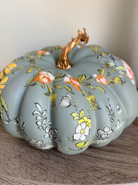 Decorative pumpkin with floral patterns on a wooden surface