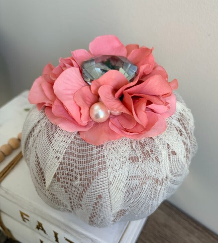 Decorative pumpkin with pink flowers and pearls on a white lace base.