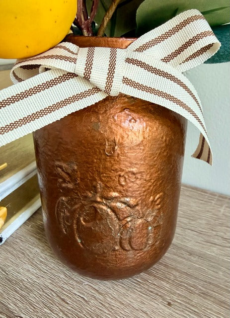 Decorative jar with a ribbon on a wooden surface