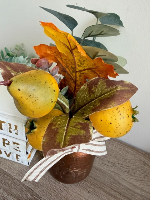 Decorative arrangement with fruits and leaves on a wooden surface