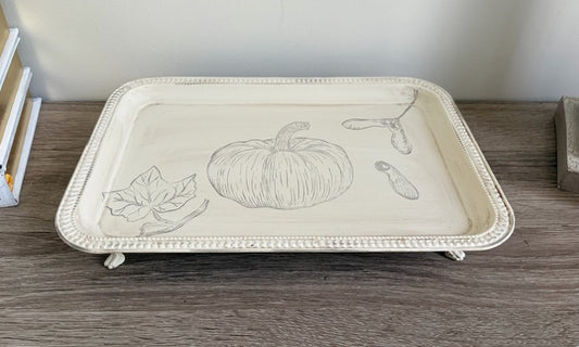 Decorative tray with pumpkin design on a wooden surface