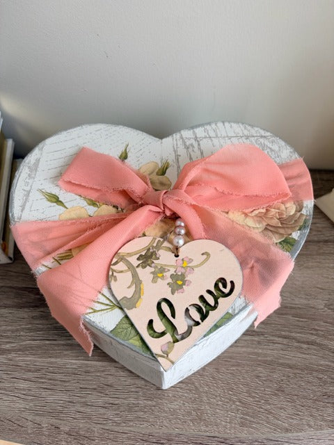 Heart-shaped gift box with pink ribbon and 'love' tag 