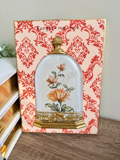 Decorative panel with floral design and gold accents on a patterned background