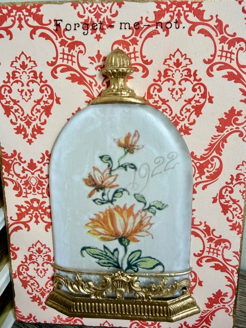 Decorative panel with floral design and 'Forget-me-not' text on a patterned background