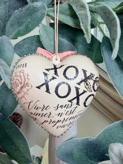 Heart-shaped decorative item with floral designs and text