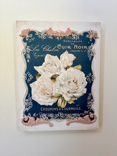 Decorative sign with floral design and text on a white background