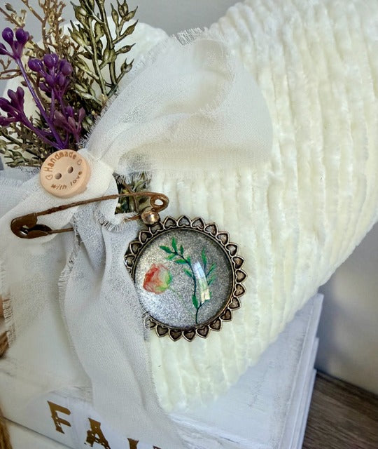 Decorative brooch with floral design on a white fabric background