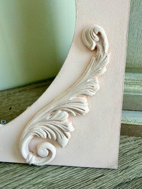 Decorative clay embellishments on a light pink surface