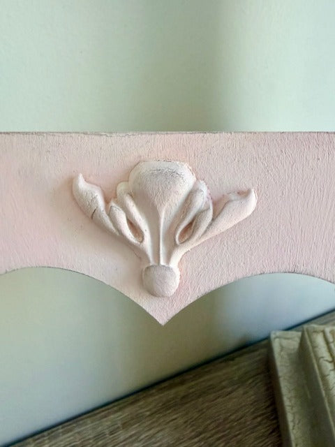 Decorative clay embellishment on a light pink surface