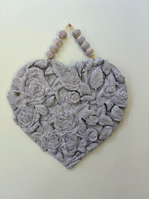 Decorative heart-shaped wall hanging with floral patterns on a light background