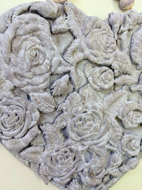 Decorative stone with embossed rose patterns on a plain background