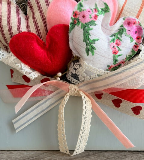 Heart-shaped decorative items with a ribbon on a wooden surface