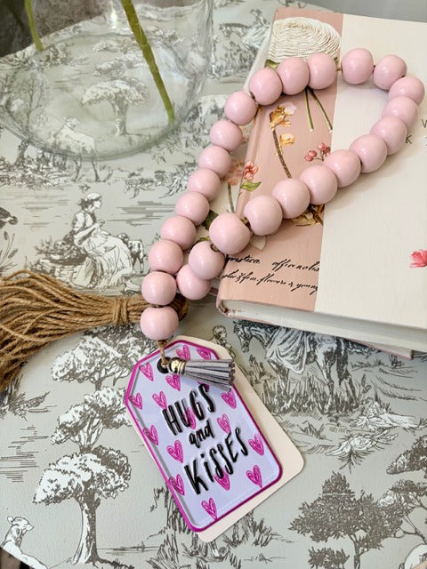 Pink beaded garland with a decorative tag 