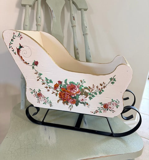 Vintage-style sleigh with floral design on a white background