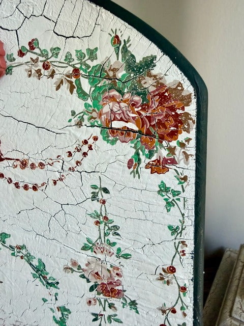 Decorative corner of a wall with floral patterns and cracked paint.