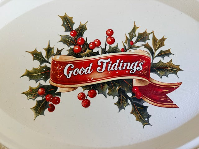 Decorative plate with 'Good Tidings' text and holly design on a white background