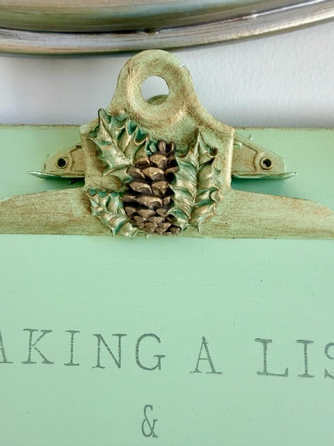 Light green clipboard with Christmas-themed decorations and text 