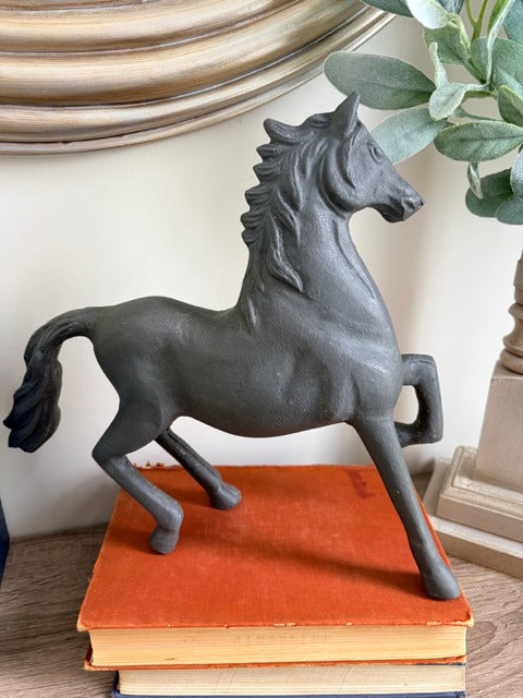 Gray horse statue on a stack of books 