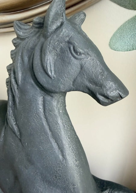 Gray stone horse sculpture on a neutral background