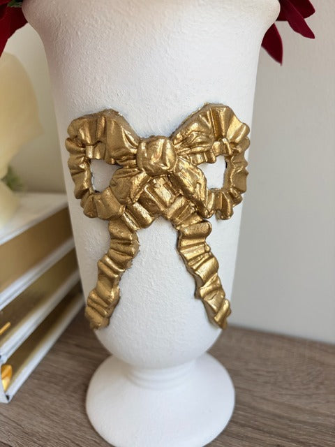 Decorative white vase with a gold bow design 