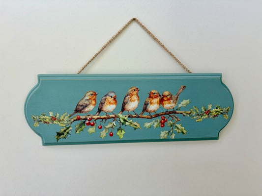Decorative sign with birds on a branch and holly leaves on a white background