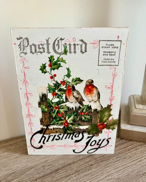 Decorative wood postcard with Christmas design featuring birds and holly and postcript