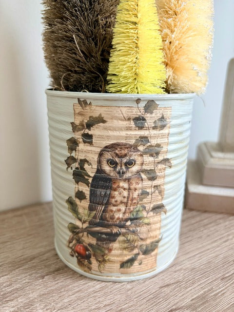Decorative pot with owl design and bottlebrush trees