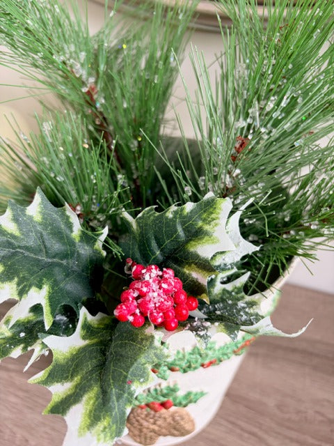 Decorative Christmas  greenery, berries, and a white center.