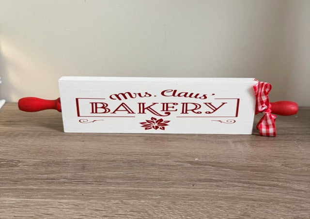 Wooden rolling pin with 'Mrs. Claus Bakery' text 