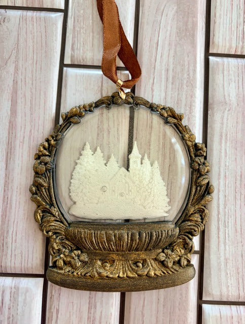 Decorative ornament with gold frame and white forest design 