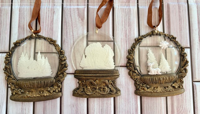 Three decorative snowglobe frames with miniature landscapes 