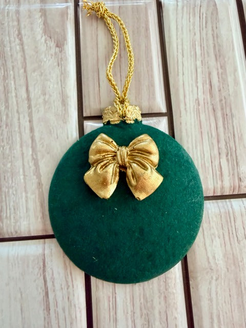 Green ornament with a gold bow