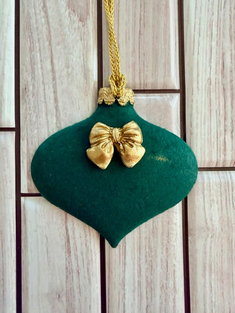 Green ornament with a gold bow 